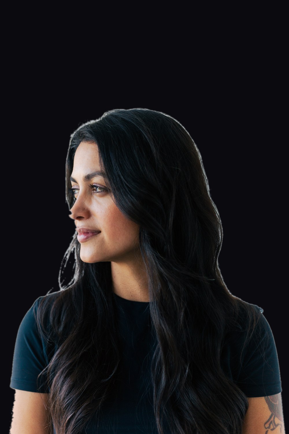 Portrait of Trinidad Araujo, product designer, against a near-black background.
